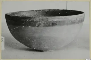 Pottery Black-on-Red II-IV bowl, deep and rounded, shown in side view against a pale background.