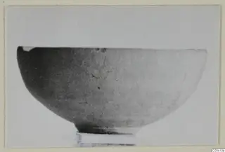 Pottery bowl seen from the side, with a crack running across its body
