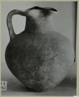 Jug with a single handle and wide trefoil-like mouth, dark surface, photographed on a plain background, from Amathus