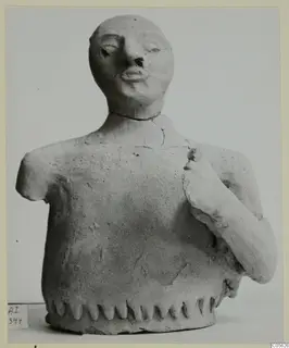 Terracotta bust from Ayia Irini with one arm broken short and the other bent up to the chest