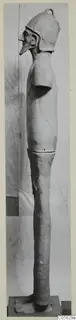 Terracotta Proto-Cypriote II figure, tall and slender, shown in profile wearing a helmet-like cap.