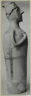 Terracotta figurine of a standing figure with one arm bent across the chest and dark painted bands on the body