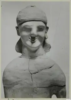 Terracotta Cypro-Greek I statuette of a figure in a close-fitting cap, with large ears and earrings, seen from the front