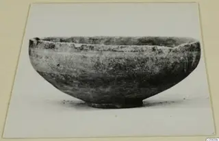 Pottery Black-on-Red II-IV bowl with a rounded body and short ring foot, shown in side view