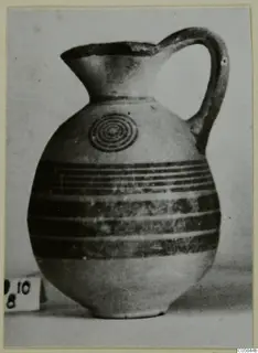 Pottery Black-on-Red II-IV jug with a concentric circle motif on the shoulder and horizontal bands around the body