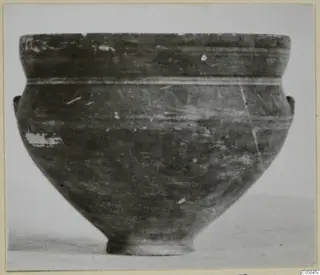 Pottery bowl with wide rim, two small lug handles and a pale line around the upper body, photographed against a plain background.
