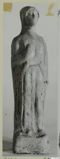 Small standing figurine on a rectangular base, photographed from Marion, finds from tombs 31–45 series.