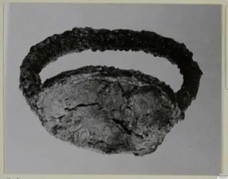 Corroded silver ring with a flattened oval bezel, seen against a plain grey background