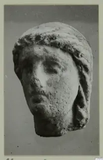 Small pale head with hair drawn back over the top and sides, from the Marion finds from tombs 46–60