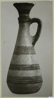 Pottery Black-on-Red II-IV juglet from Amathus with a flared neck, single loop handle and dark horizontal bands