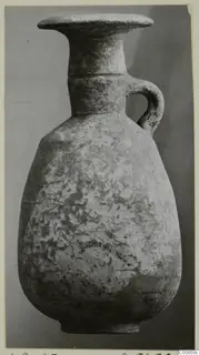 Pottery juglet from Amathus with a flared rim and single loop handle, shown against a grey background