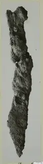 Corroded iron knife from Marion Tomb 75, photographed against a pale background.