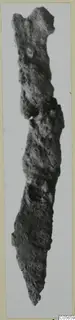 Corroded iron knife from Marion Tomb 75, shown upright against a pale background.