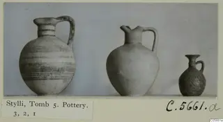 Three pottery jugs of decreasing size standing in a row, from Stylli, Tomb 5