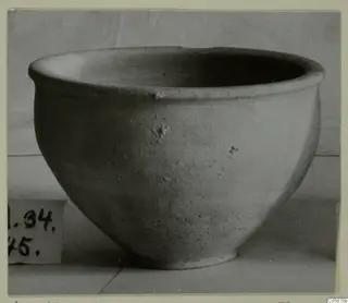 Plain pottery bowl with a rounded body and flaring rim, from Marion tombs 31–45, with a number label at left