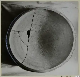 Pottery Plain White VII, a shallow bowl seen from above, broken and mended with visible cracks across its interior.