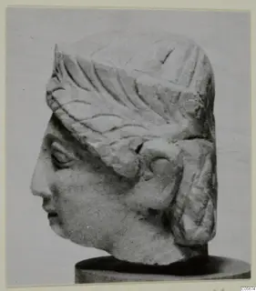 Limestone head of a figure from Mersinaki, shown in profile on a round dark base