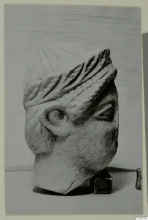 Carved limestone head from Mersinaki, broken off at the base, shown three-quarter view