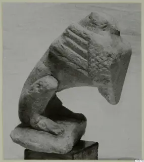 Limestone sculpture fragment from Vouni, with a grooved upper section and a small limb-like projection, set on a wooden block