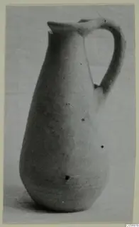 Plain white pottery jug with a tall neck, trefoil-type spout and a single loop handle, photographed on a pale ground.