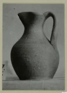 Pottery juglet, Plain White VI, with a single handle, shown against a grey backdrop