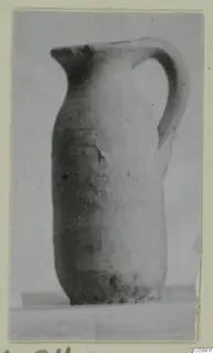 Pottery Plain White VII juglet with a single curved handle, shown in side view