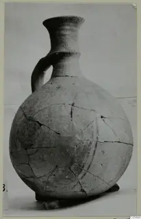 Jug with a single strap handle, a flaring neck and a rounded body, photographed against a plain pale background
