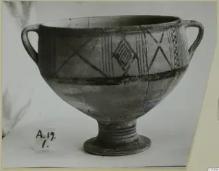 White Painted II bowl with two loop handles and a ring foot, decorated with dark painted bands and crossed lines