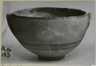 Pottery Black-on-Red I-III bowl with two small handles and dark bands around the body, seen from the side