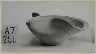 Terracotta lamp from Amathus with a rounded body and a small handle, photographed in side view.