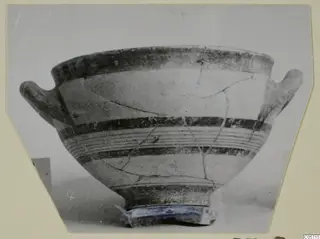Two-handled bowl with dark painted bands and a footed base, photographed on a cream card mount, from the Amathus tombs series