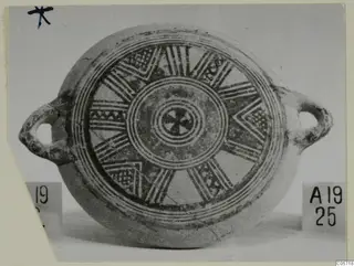 Pottery Bichrome II plate with two loop handles and painted concentric rings and radiating bands