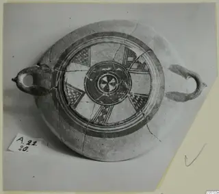 White Painted I bowl with two handles, painted concentric bands and checkered panels in the centre, photographed from above