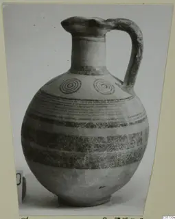 Black-on-Red I-III pottery jug with a strap handle, dark painted bands and concentric circles on the shoulder