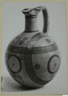 Jug with black painted bands, concentric circles and large rings, from the Pottery Black-on-Red II-IV series.