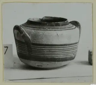 Pottery Bichrome IV jug with two handles and horizontal bands of paint, photographed on a pale surface