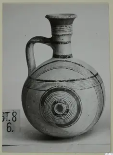 Pottery Bichrome III jug with a flared neck, a single loop handle and concentric circles painted on its body.