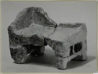 Broken pale object from Marion with an incised chevron pattern on one side and short legs or supports