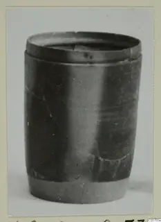 Dark, smooth-surfaced vessel with a raised rim band, photographed upright against a pale background