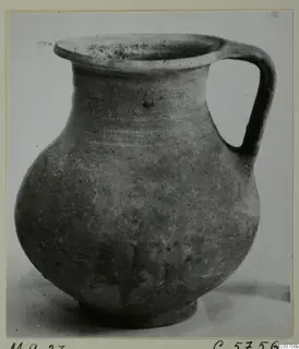 Jug with a wide flared rim, single loop handle and rounded body, photographed on a plain background.