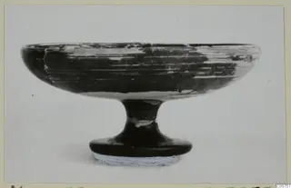 Black-glazed kylix from Marion, tombs 46–60: a shallow footed bowl shown in side view against a plain background