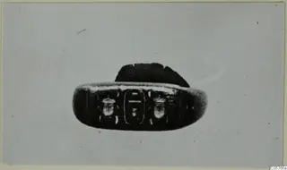 Oval engraved seal with two beetle-like figures flanking a central motif, shown in close view
