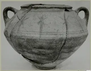 Two-handled painted pottery crater with radiating motifs and horizontal bands, photographed upright against a plain background.