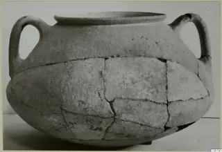 Two-handled crater in pottery, reconstructed from joined fragments, shown in side view against a plain background.