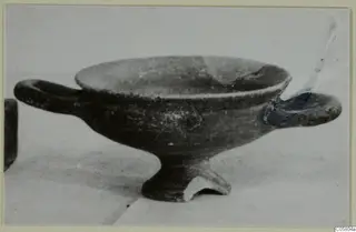 Kylix, a two-handled footed bowl with a dark surface, shown in side view on a pale background