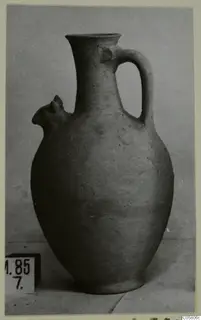 Pottery jug with a tall neck, a loop handle and a small projecting lip
