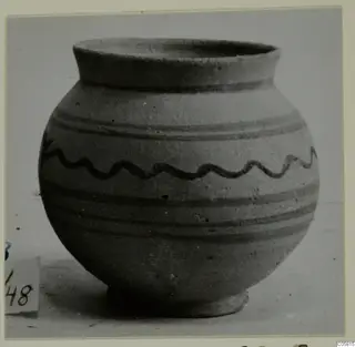 Globular pot with flared rim and dark painted bands and a wavy line on a pale buff surface