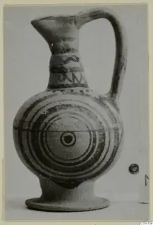 Black-on-Red jug with a flaring mouth and concentric circles on its body.