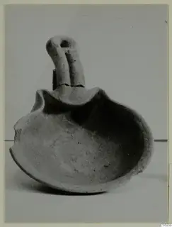 Terracotta lamp with a shallow rounded body, a pinched wavy rim and a loop handle rising from the back