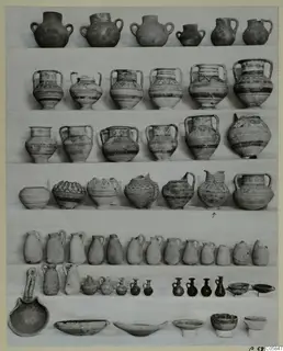 Rows of pottery vessels from a deposit at Idalion, jugs, bowls and small juglets set out on a white cloth.